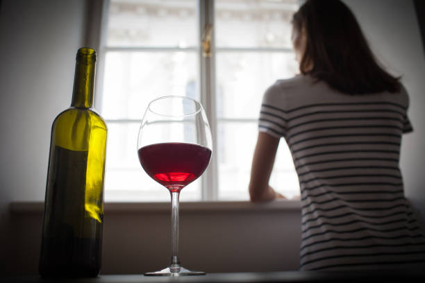 woman drinking wine alone in the dark room - alcohol alcoholism addiction drinking imagens e fotografias de stock