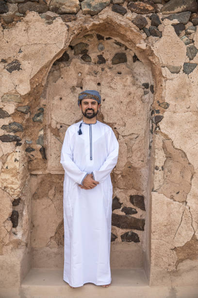 arab man in traditional omani outfit omani man smiling for the camera arabian sea photos stock pictures, royalty-free photos & images