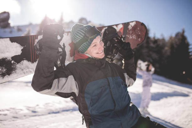istock Snowboarder Posing Cheerfully With His Snowboard 916256078