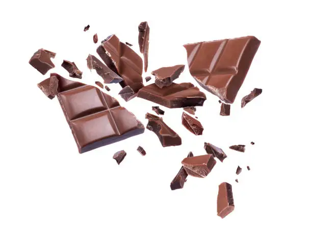 Photo of Ð¡hocolate broken into pieces in the air on a white background