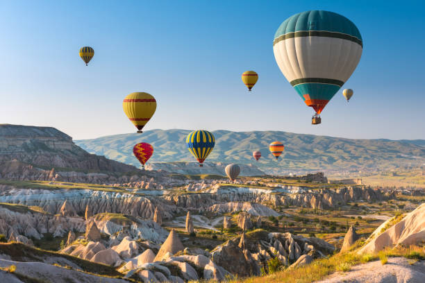 Hot air balloons flying over Cappadocia, Turkey Hot air balloons flying in sunset sky Cappadocia, Turkey cappadocia photos stock pictures, royalty-free photos & images
