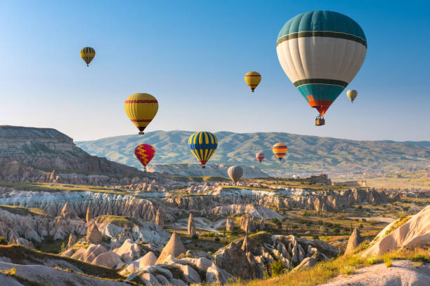 Hot air balloons flying over Cappadocia, Turkey Hot air balloons flying in sunset sky Cappadocia, Turkey nevsehir stock pictures, royalty-free photos & images