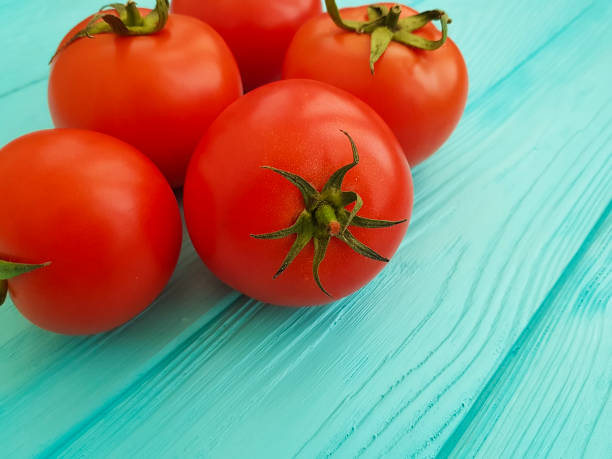istock ripe red tomatoes on blue wooden 916260314
