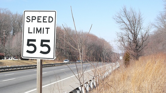 A closeup of a newly installed twenty miles per hour speed limit sign.