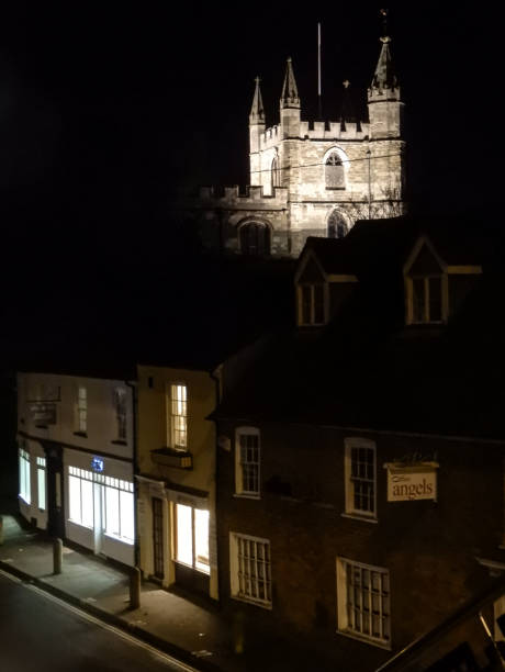 Night shot of the iit tower of St Michaels curch behind some offices and shops on Church St Basingstoke, United Kingdom - January 10 2018:   Night shot of the iit tower of St Michaels curch behind some offices and shops on Church St basingstoke photos stock pictures, royalty-free photos & images