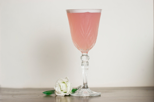 Pink cocktail on the white background, close up