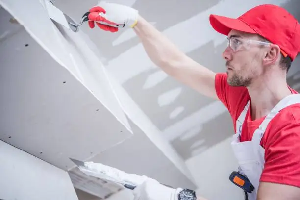 Residential Remodeling Drywall Patching. Caucasian Contractor in His 30s. Construction Theme.