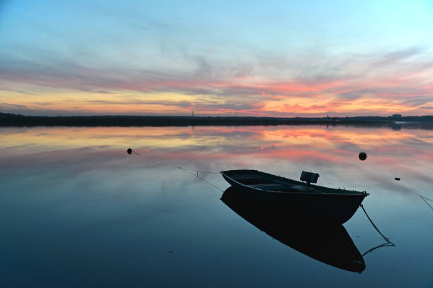 A boat on the pond of Canet Saint Nazaire, at dusk, in autumn - France.