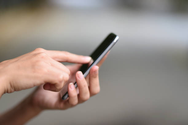 istock Young woman is using mobile phone, close-up 916283538