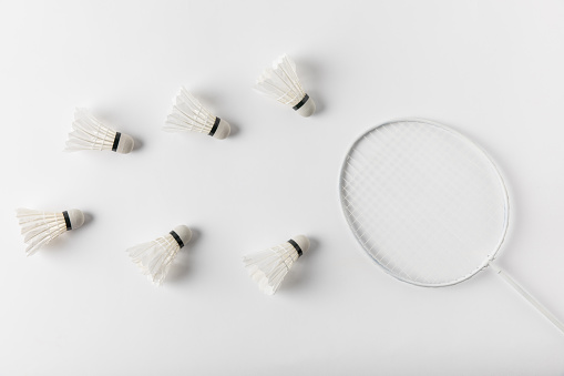top view of badminton shuttlecocks and racket on white tabletop