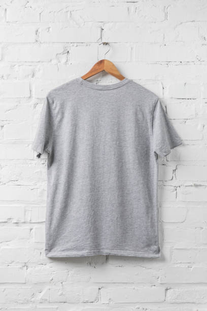 одна серая рубашка на вешалке на белой стене - gray shirt стоковые фото и изображения