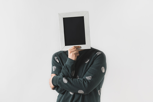 man covering face with black board isolated on white