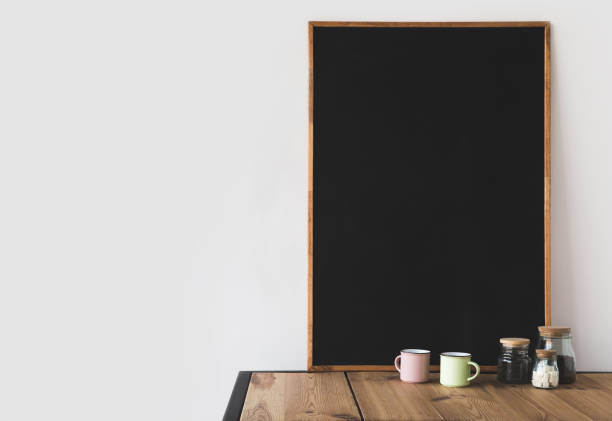 istock cups and coffee with big empty blackboard on wooden table on white 916288784