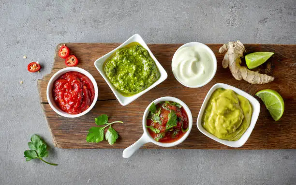 Photo of various dip sauces on grey table