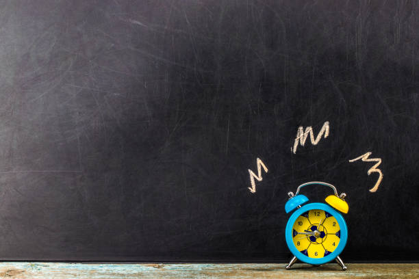 istock Ringing alarm clock on dark background, suggesting wake-up time or deadline.With copy space 916301024