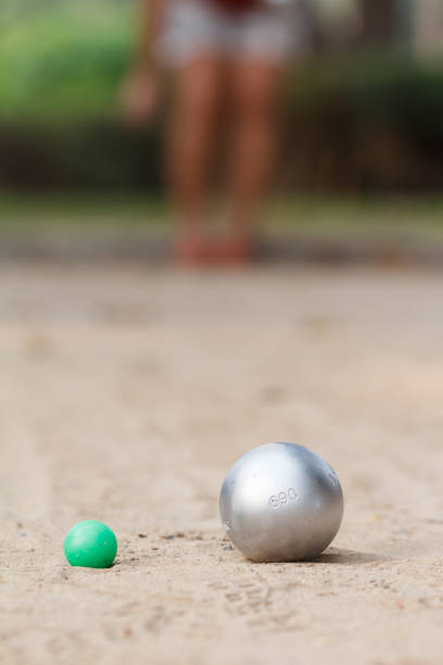 istock Boules or petanque ball in the match and player in back 916306686