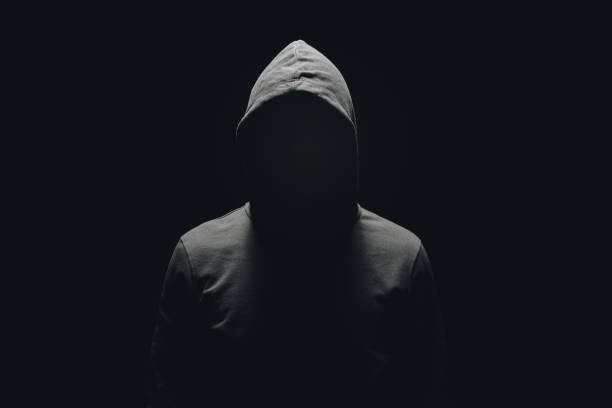 der mann ohne gesicht in hoodie stehen isoliert auf schwarz - kapuzenoberteil stock-fotos und bilder