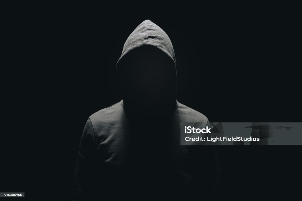 homme sans visage en hoodie debout, isolée sur fond noir - Photo de Hommes libre de droits