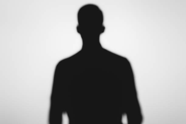 istock mysterious blurry shadow of spooky person standing on grey 916307690