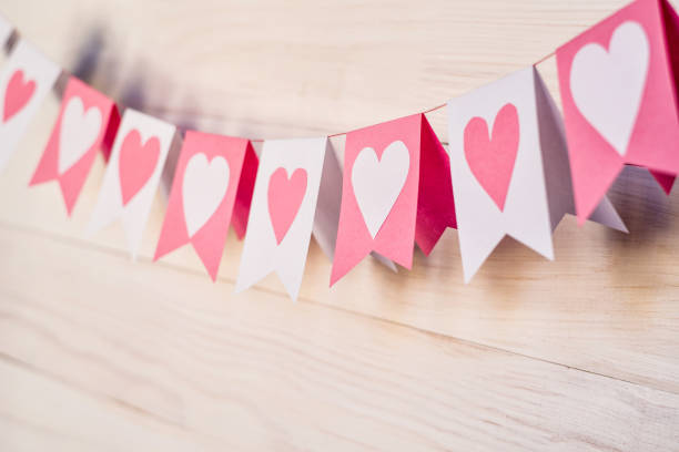 istock valentine day concept. white and pink flags hangingon a rope on white rustic background 916307784