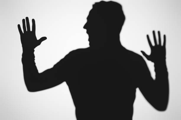 istock scary blurry shadow of person screaming on grey 916310542