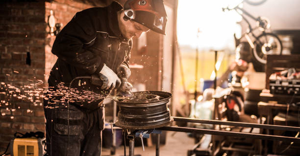 istock Happy mechanic grinding on a steel wheel. 916310732