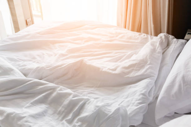 istock unmade rumpled bed with white messy pillows  in bedroom interior morning light 916313984