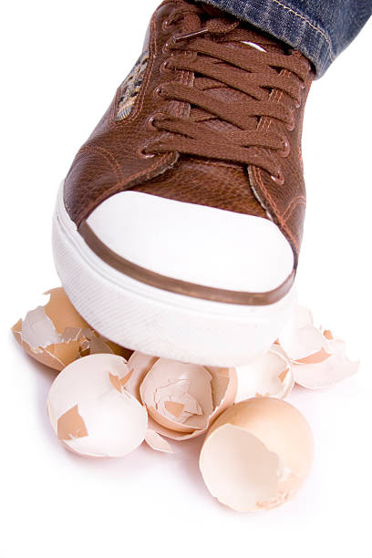 Crushing eggs See my other 'walking on eggshell' images. Shoe walking on eggshells. animal egg walking on eggshells walking broken stock pictures, royalty-free photos & images