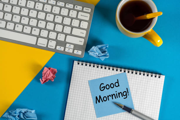 istock Good morning - is written on small notepad with a cup of coffee, pen, keyboard on bright workplace at office or home 916330056