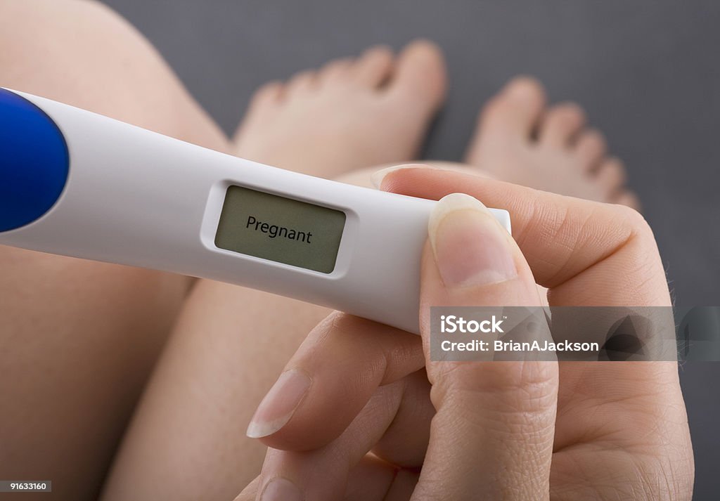 Positive result of pregnancy test Woman taking a pregnancy test showing pregnant result Pregnancy Test Stock Photo