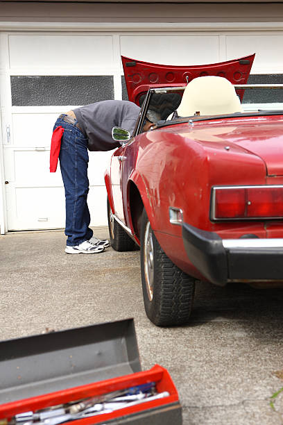 istock Man looking under hood of classic car 91633681