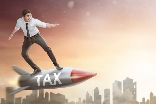 Happy asian businessman flying on rocket with Tax text. Taxation concept