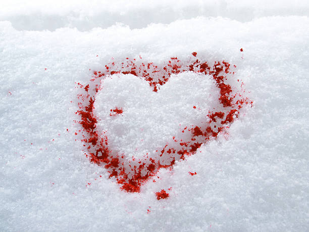 decorative red heart figurine on snow background
