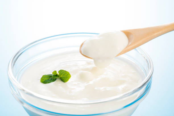 yogourt dans un bol en verre, à l’aide d’une cuillère en bois - lactobacillus photos et images de collection