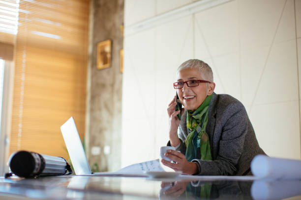 istock Mature female architect working on blueprint 916380314