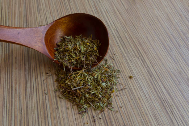 istock Leaves medicinal herbs in a wooden spoon texture 916388776