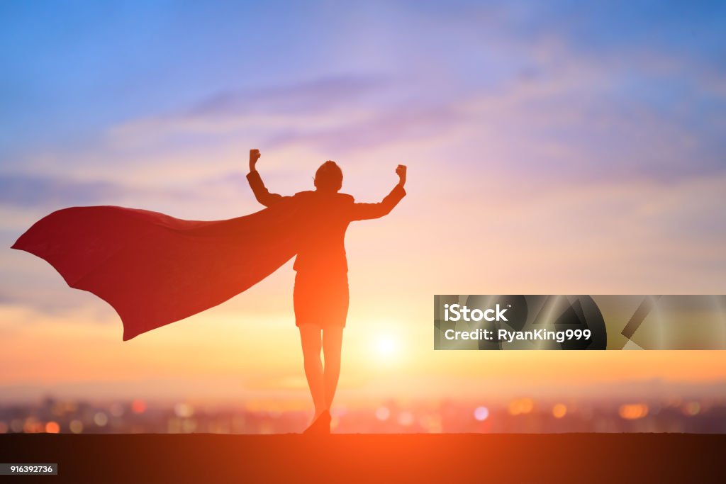 silhouette of super business woman silhouette of super business woman feel strong with sunset Superhero Stock Photo