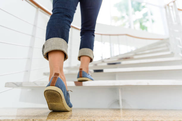 adulto joven subiendo las escaleras con el fondo de deporte de sol. - black ladder white staircase fotografías e imágenes de stock