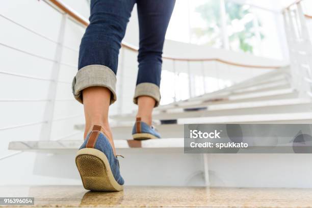 Young Adult Woman Walking Up The Stairs With Sun Sport Background Stock Photo - Download Image Now