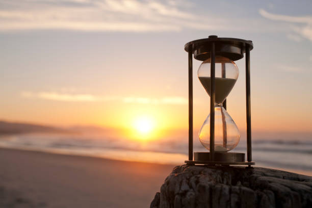 песочные часы на beaxh на sunsrise, - twilight time стоковые фото и изображения