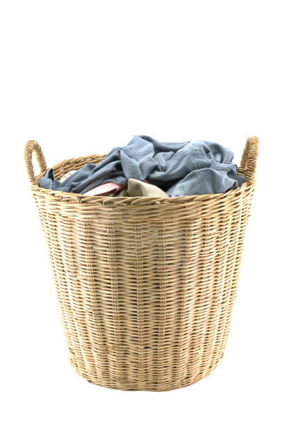 istock Clothes in a laundry wooden basket isolated on white background. 916399830