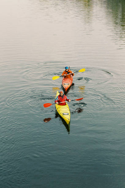Two men are kayaking along the river.