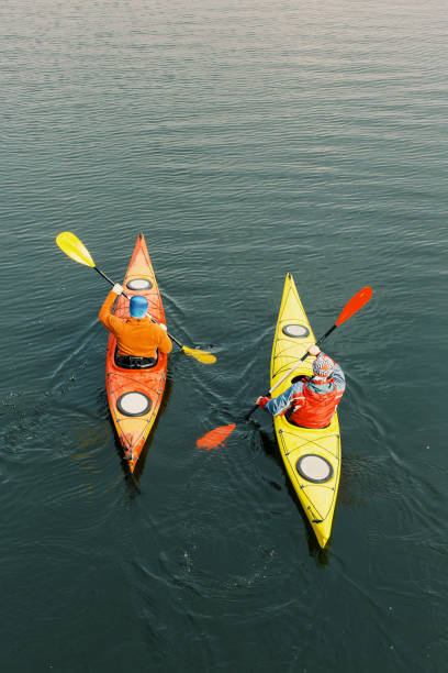 Two men are kayaking along the river.
