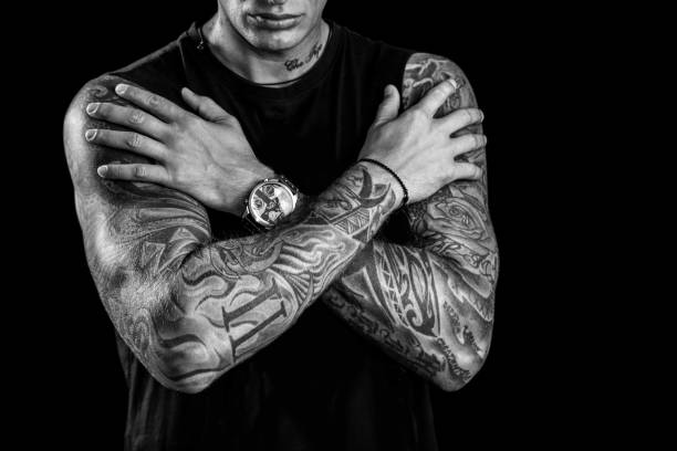 Tattoo sleeves Young man with tatoo sleeves posing in studio, isolated on black background. About 25 years old, Caucasian male. tattoo arm stock pictures, royalty-free photos & images