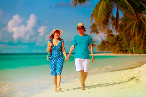 istock happy loving couple walking on tropical beach 916407898
