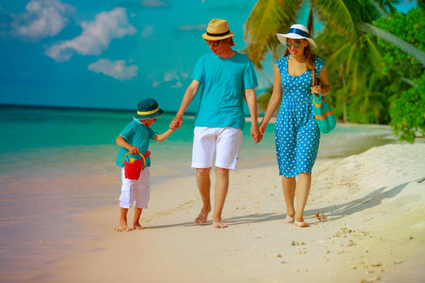 istock family with child walking on tropical beach 916407974