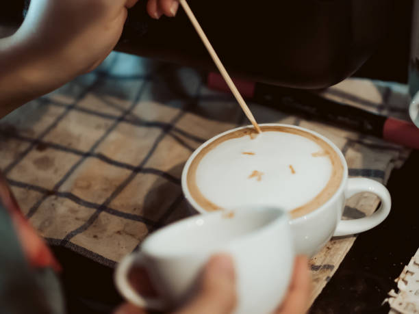 istock Barista drawing Latte art on the coffee with a small stick. 916408556