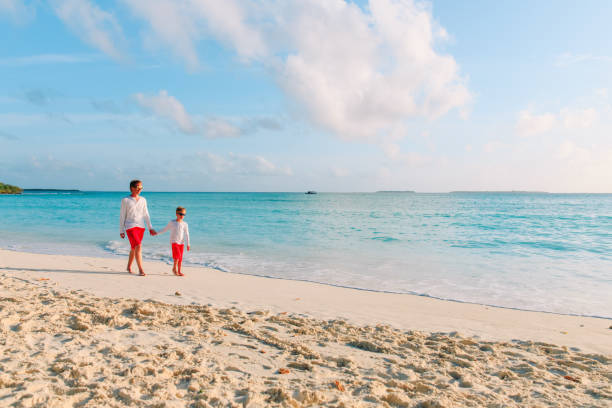 istock father and son walking on beach 916411142