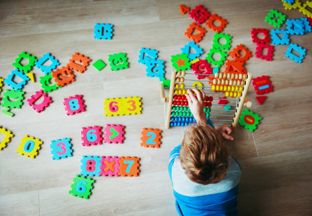 istock little boy calculating on abacus, playing with number puzzle 916412124