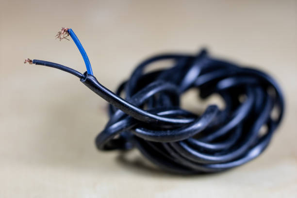 istock Electric cables, plugs and connectors on a wooden workshop table. Accessories and electrical components. Black background. 916414024